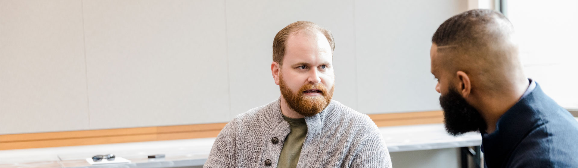 Two men talking in a group meeting