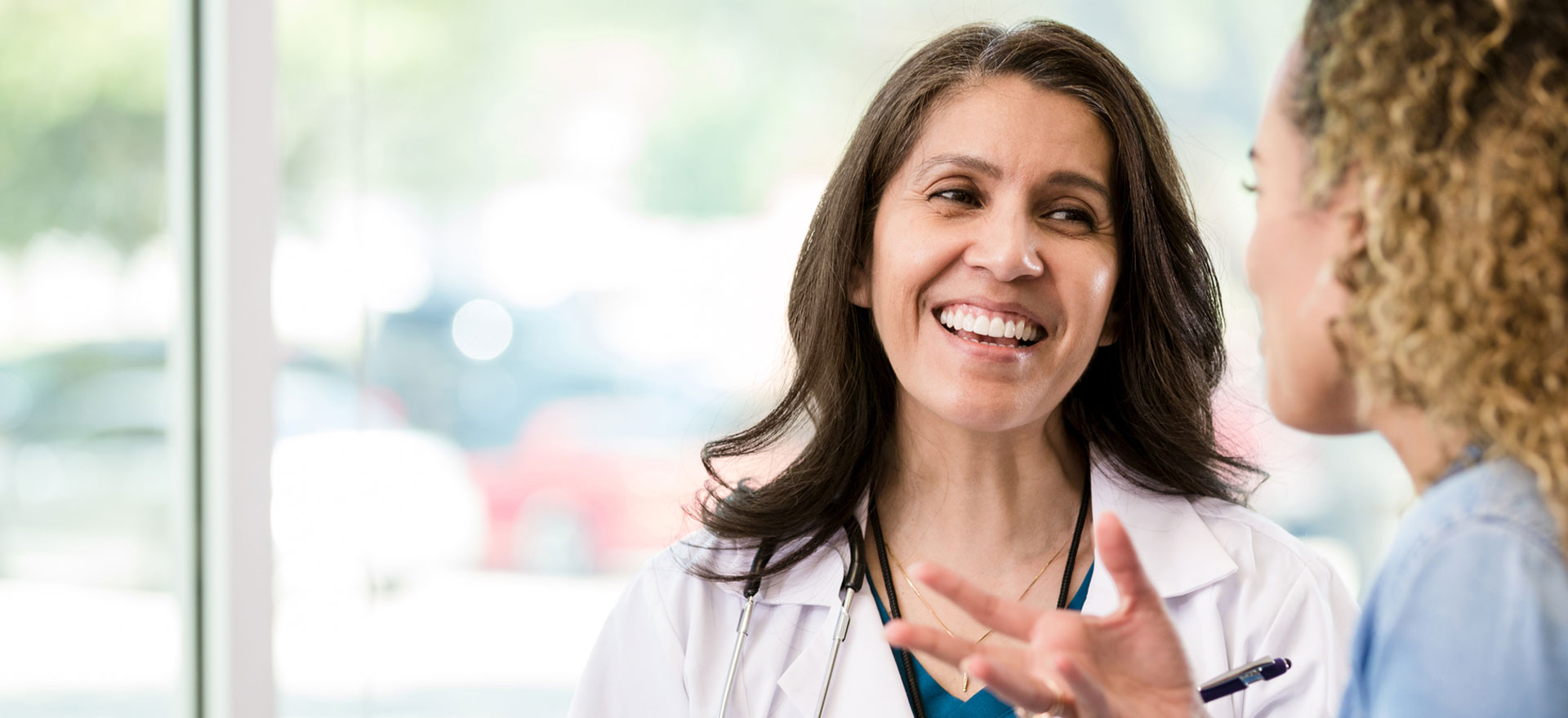 Female provider smiles as she talks to a patient