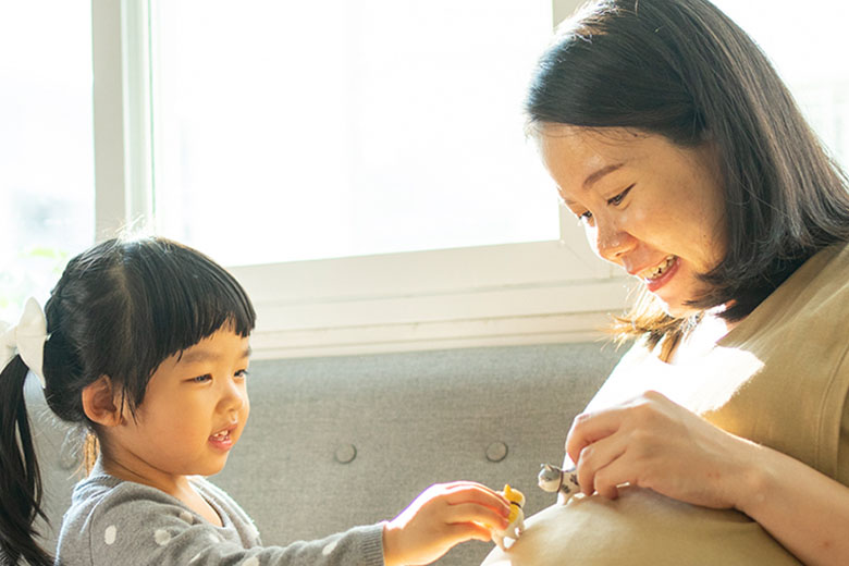 Pregnant Asian Mother with Daughter
