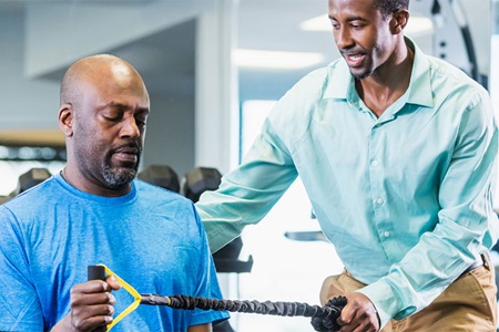 Physical therapist helping man strengthen arm